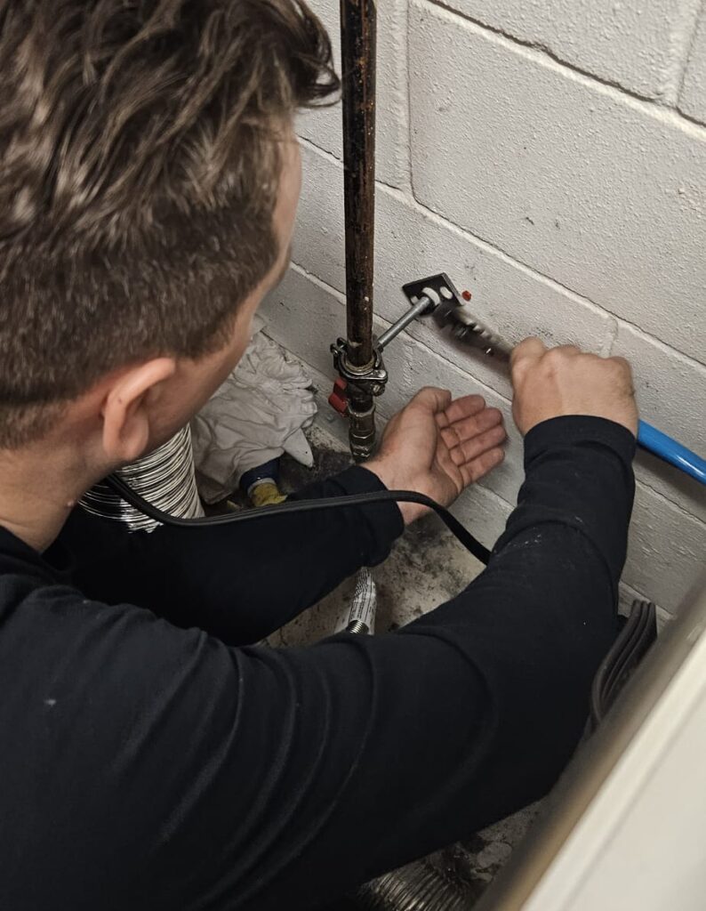 Plumber installing support for gas pipe