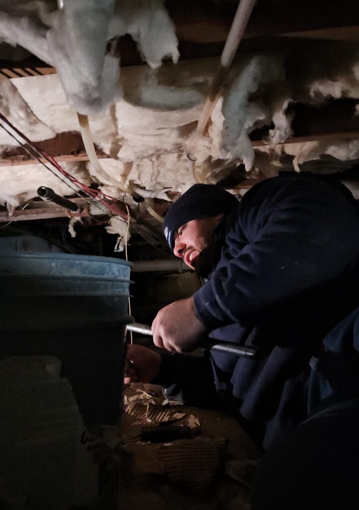 Plumber working in crawlspace