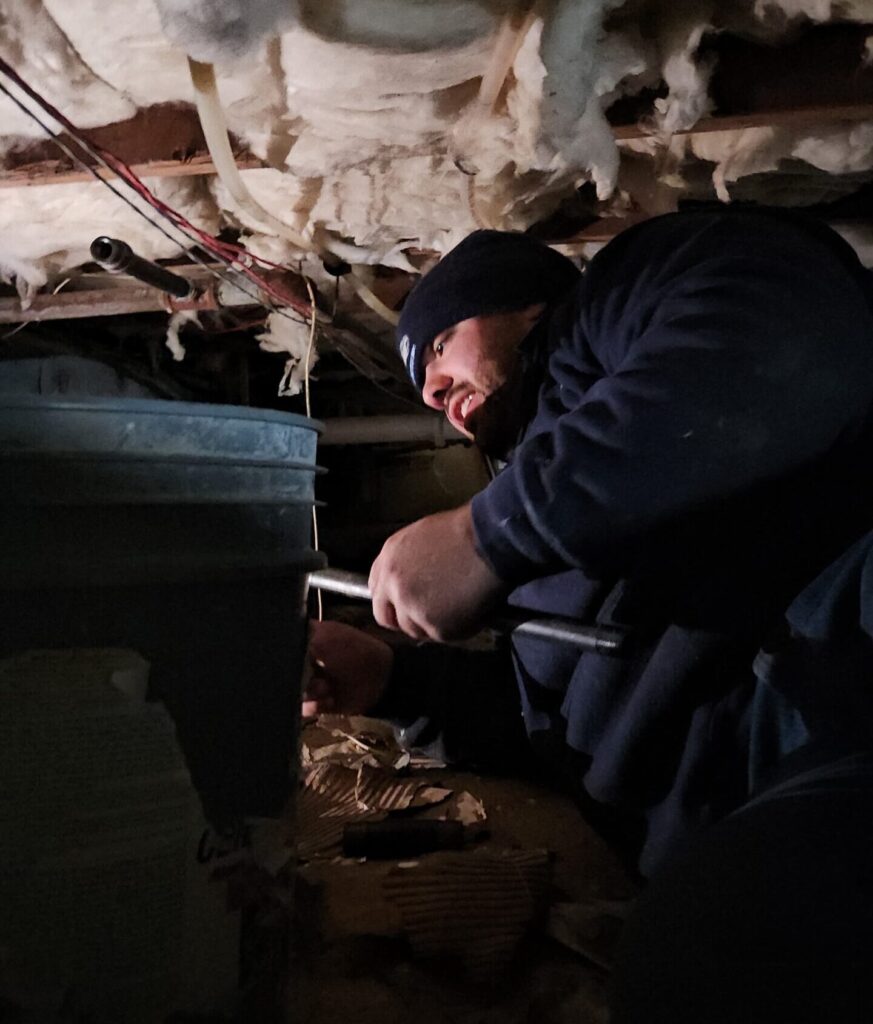 Plumber working in crawlspace
