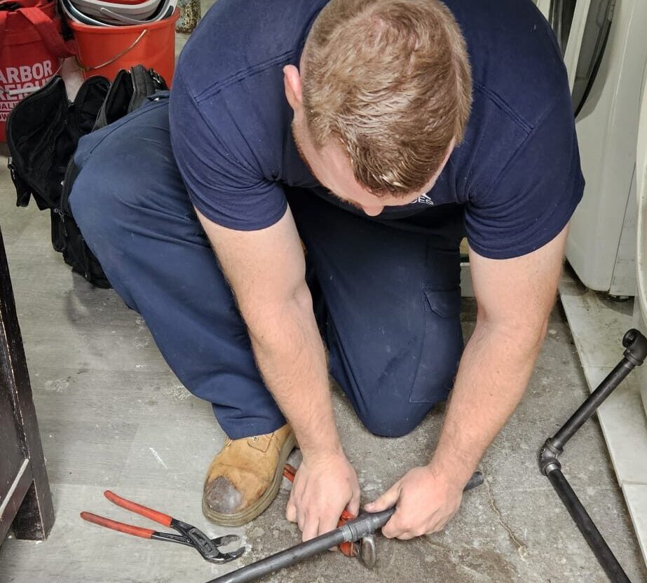 Plumber using wrench on pipe