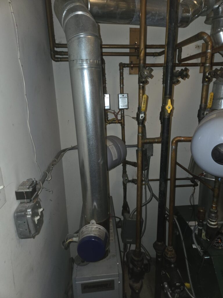 Boiler room mechanical setup with copper and black gas piping, Ariel Service Inc, valves, expansion tank, and venting connected to the water heater.