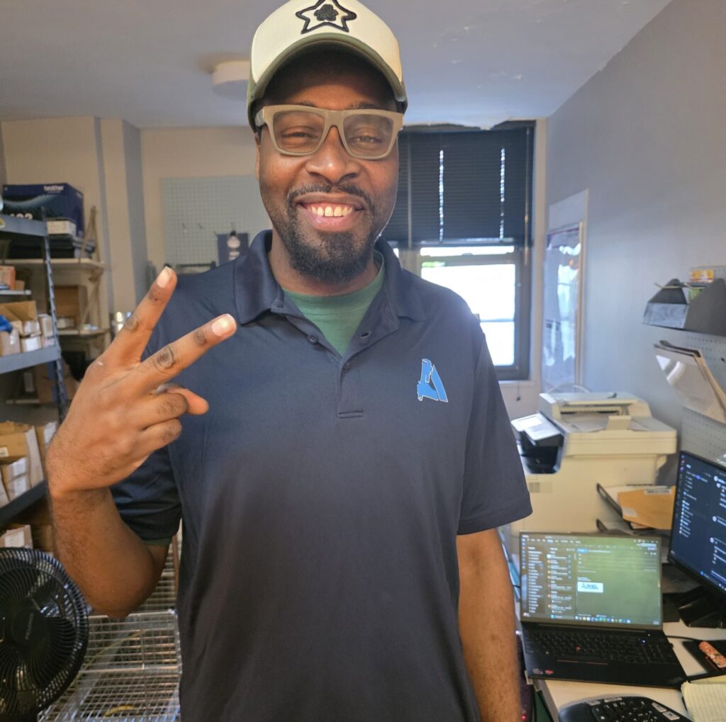 Team member in the office wearing Ariel Services shirt and smiling
