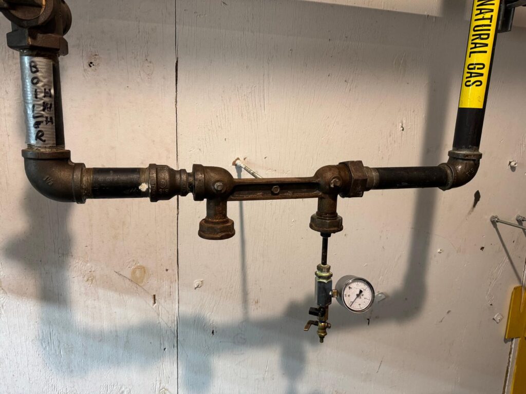 Natural gas meter bar with pressure gauge attached, to complete a gas integrity test