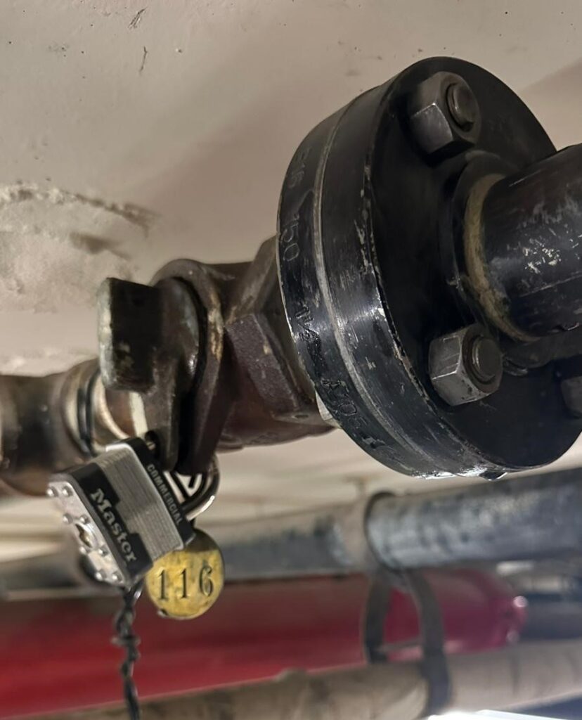 Padlock in lockwing valve on gas riser, ensuring the gas remains shut off until all repairs are complete